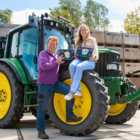 Familie bij de groene tractor met originele Flowerbulbs Amsterdam-verpakkingen